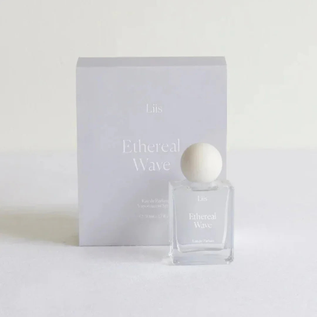 Parfümflakon "Ethereal Wave" von Liis, ein minimalistisch gestalteter, klarer Flakon mit rundem weißen Verschluss.