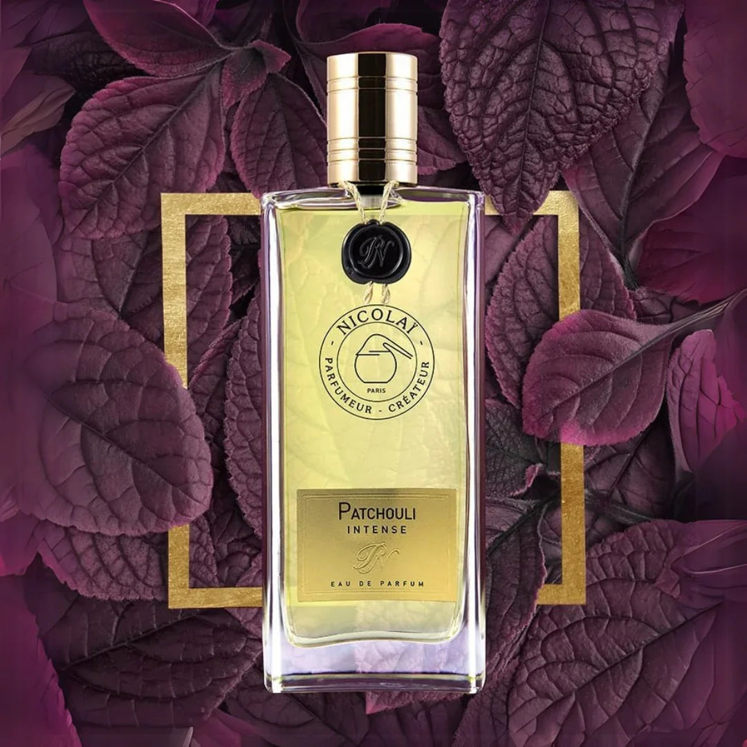 Nicolaï PATCHOULI INTENSE Eau de Parfum Flakon vor lila Blättern scent amor