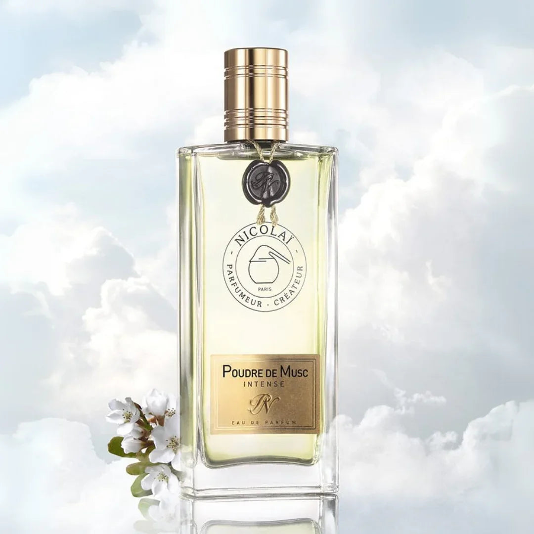 Nicolaï POUDRE DE MUSC INTENSE Eau de Parfum Mood Flakon vor Wolkenhimmel mit Apfelblüten scent amor