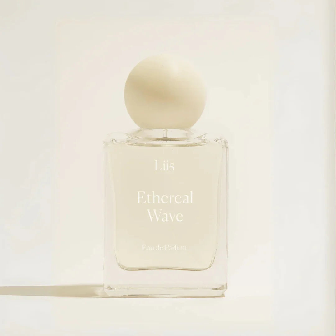 Parfümflakon "Ethereal Wave" von Liis, durchsichtig mit weißer Kappe und Aufschrift auf der Vorderseite des Flakons.