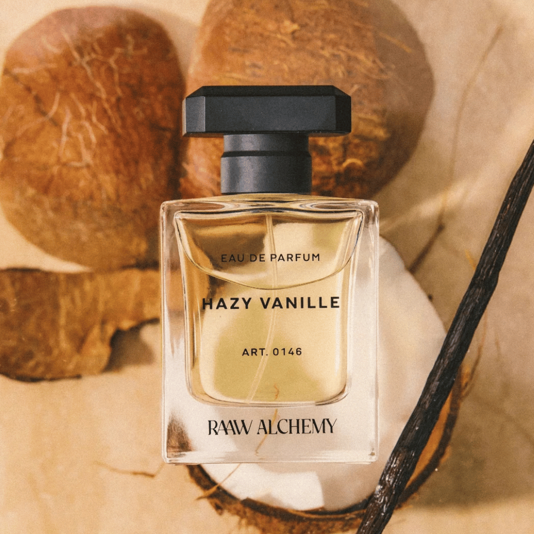 RAAW ALCHEMY Hazy Vanille Eau de Parfum Nischenduft Flakon vor Kokosnüssen und Vanille Schote präsentiert bei scent amor