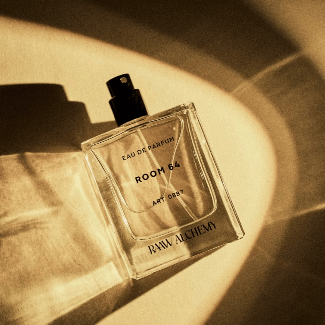RAAW ALCHEMY ROOM 64 Eau de Parfum liegend auf goldenem Hintergrund mit Lichtreflexen bei scent amor Fachmann für Nischenparfums