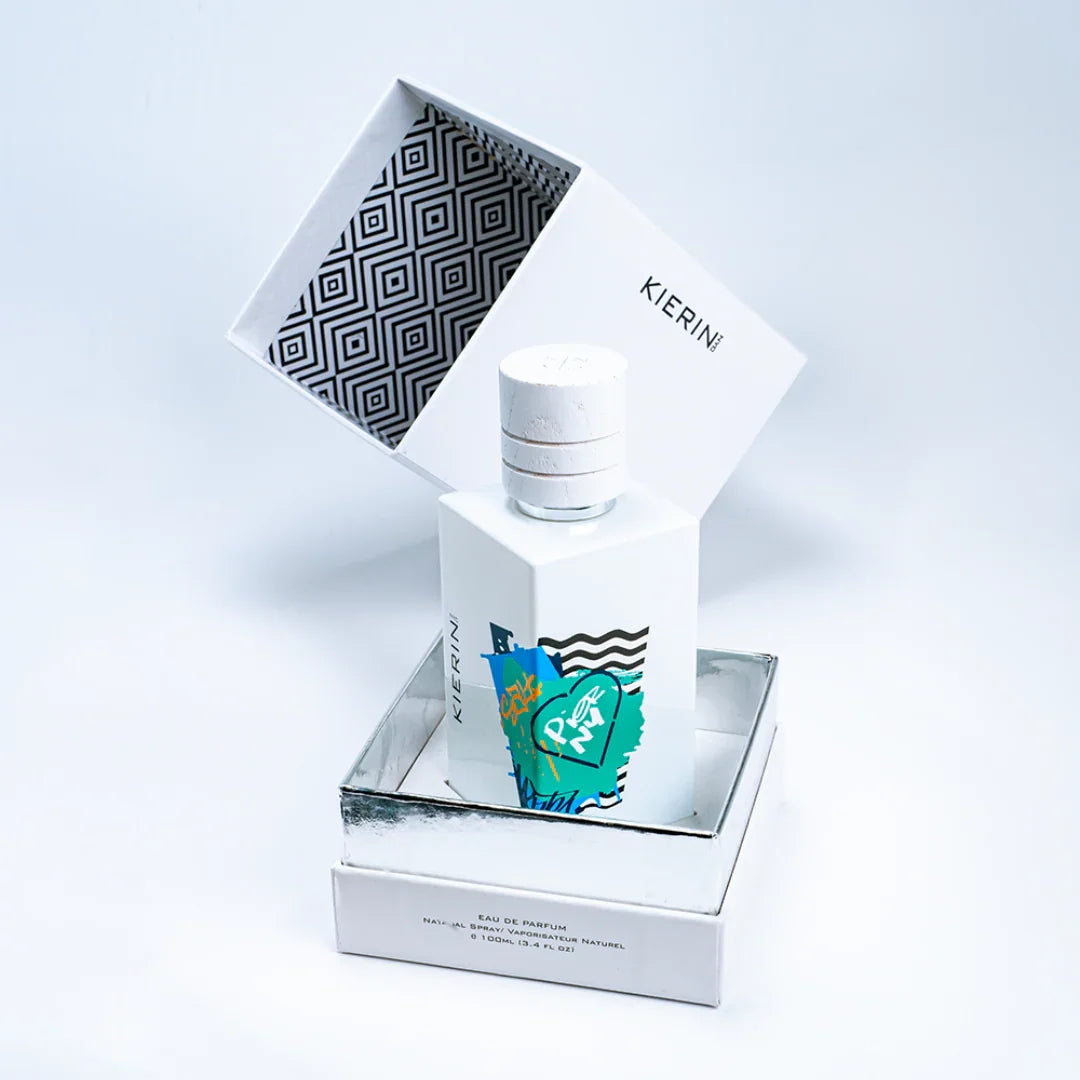 Parfümflakon "Pier NY" von Kierin NYC. Weiße, rechteckige Flasche mit grafischen Mustern in Blau und Grün. Geöffnete Verpackung.