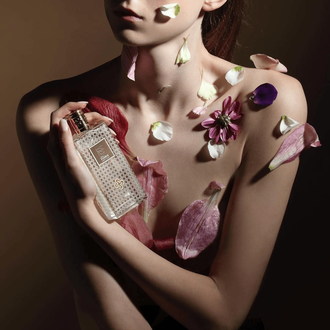 weiblicher Oberkörper bedeckt mit Blütenblättern und einem Flakon in der Hand on Perris Monte Carlo