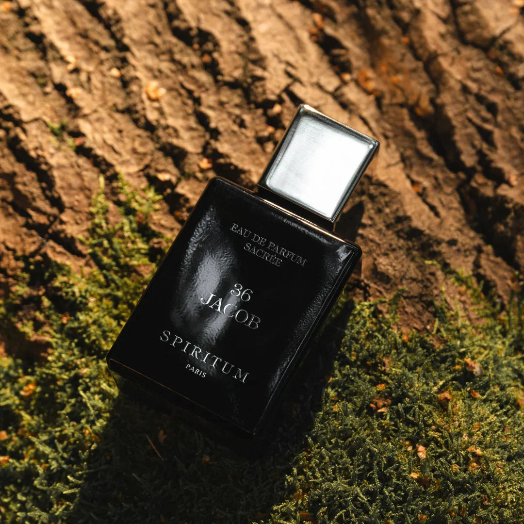 Spiritum Paris JACOB Eau de Parfum – der Flakon liegt schräg auf weichem Moos und rauem Holz, von Sonnenlicht durchflutet – ein Bild, das die harmonische Verbindung von Natur und Duftkunst inszeniert – erlebe es bei scent amor