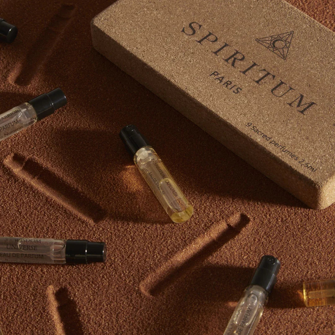 Spiritum Paris Numerus Collection Discovery Set – Abdrücke der Proben im Sand, begleitet von der eleganten Verpackung und verstreuten Proben – eine Szene, die die sinnliche Vielfalt der Kollektion widerspiegelt – erlebe es bei scent amor