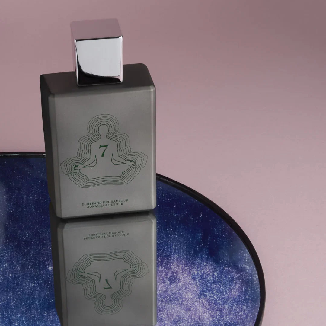 Spiritum Paris SPIRITUAL EXPLORER Eau de Parfum – der Flakon steht auf einem runden Spiegel, der wie ein Fenster ins Universum eine schimmernde Galaxie reflektiert – eine visuelle Einladung, in die grenzenlose Welt der Düfte einzutauchen – erlebe es bei scent amor