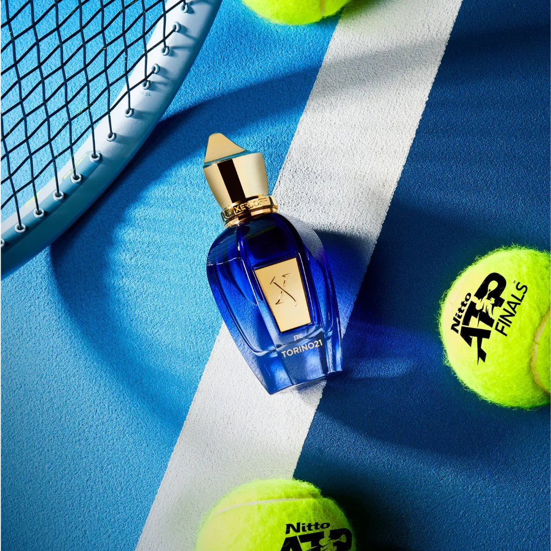 Xerjoff Torino 21 Eau de Parfum – sportlich inszenierter Flakon zwischen Tennisschläger und Tennisbällen, ein lebendiger Nischenduftmoment, exklusiv bei scent amor erleben