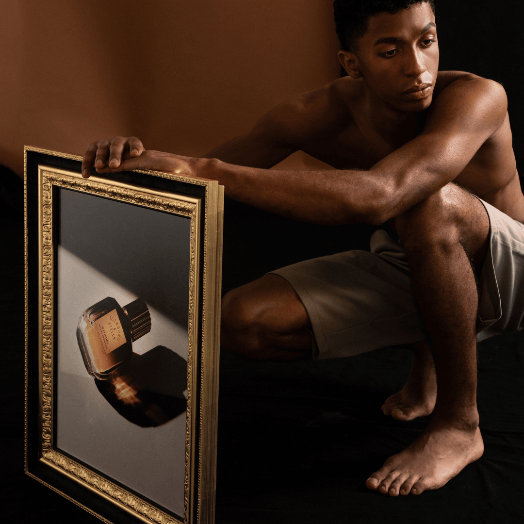 Astrophil & Stella In Extremis Extrait de Parfum – Flakon als Kunstwerk im Rahmen, gehalten von einem Mann, Symbol für künstlerische Ausdruckskraft bei scent amor