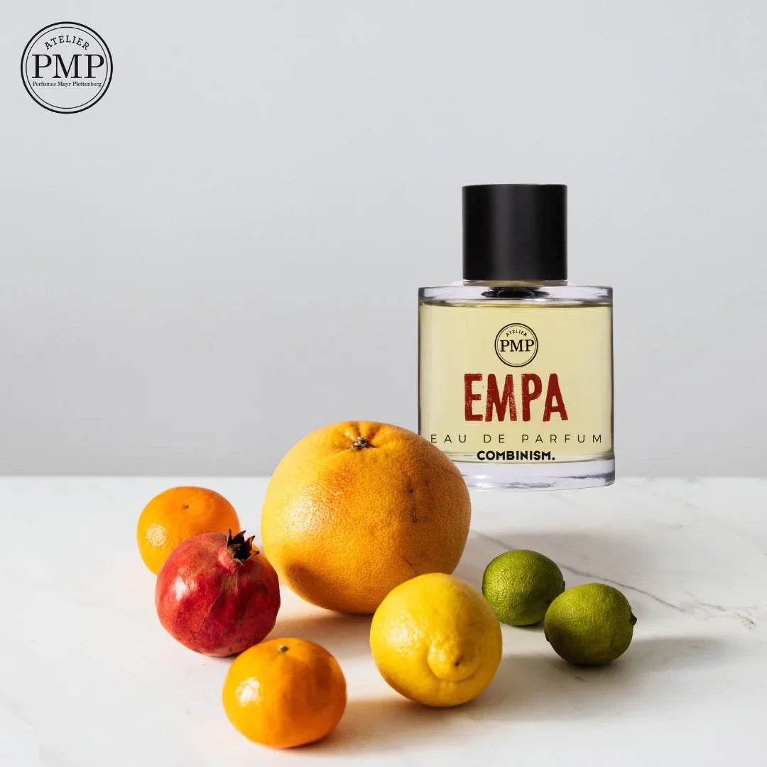 flakon von dem eau de parfum empa von atelier pmp hinter zitrusfrüchten