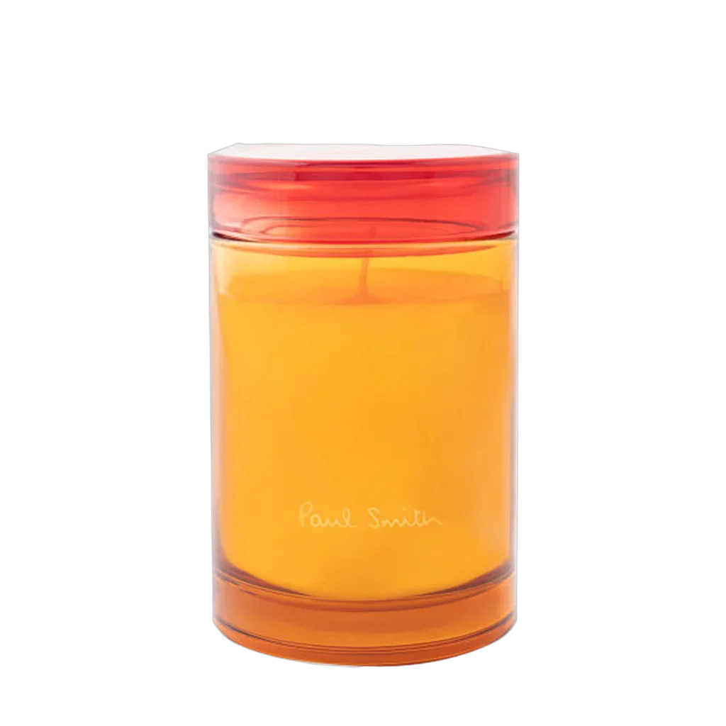 Duftkerze in einem transparenten Glas mit orangefarbenem Wachs und rotem Deckel. Produktname: Bookworm Duftkerze. Anbieter: Paul Smith.