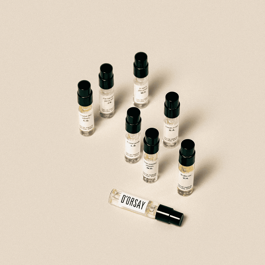 D’Orsay Les Découvertes Olfactives Discovery Set, einzelne Duftproben locker auf hellem Untergrund verteilt mit Fokus auf einer liegenden Probe, erhältlich bei scent amor.