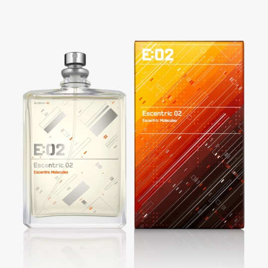 Escentric Molecules Escentric 02 Eau de Toilette mit Flakon und Verpackung, klarer Flakon trifft auf grafisch gestaltete Box in warmen Orangetönen, moderner Nischenduft, erhältlich bei scent amor.