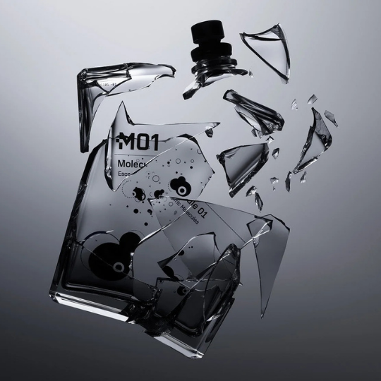 Escentric Molecules Molecule 01 Eau de Toilette, zerbrochener Flakon mit schwebenden Glassplittern als künstlerische Darstellung, minimalistischer ikonischer Duft, erhältlich bei scent amor.