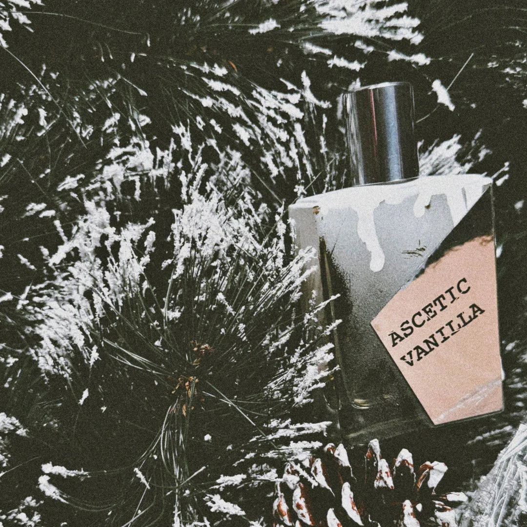 flakon von dem unisex extrait de parfum ascetic vanilla von filippo sorcinelli zwischen tannenblättern und schnee