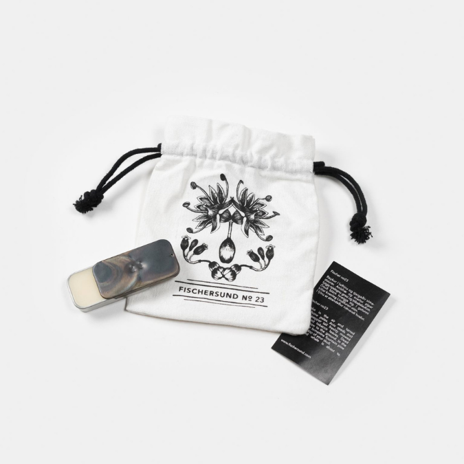 Fischersund No. 23 Solid Perfume, kompakter Duftflakon mit Stoffbeutel und Produktkarte arrangiert, ruhig und authentisch dargestellt, erhältlich bei scent amor.
