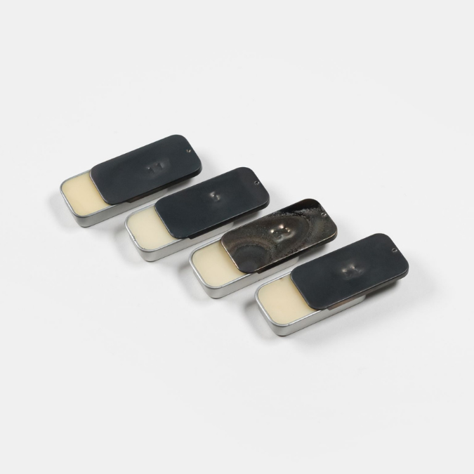 Fischersund Solid Perfumes, mehrere kompakte Duftflakons aus Metall mit sichtbarer Creme nebeneinander arrangiert, minimalistisch dargestellt, erhältlich bei scent amor.