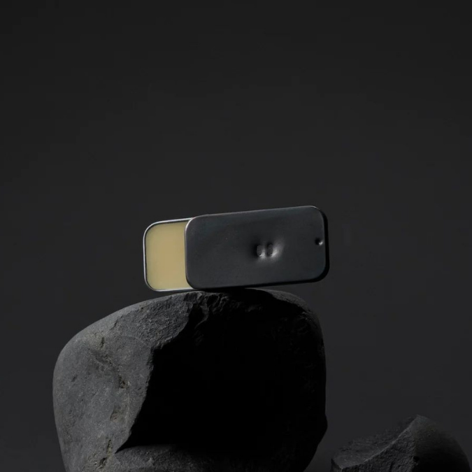 Fischersund X 66°Norður ÚTILYKT Solid Perfume, kompakter Duftflakon auf dunklem Stein inszeniert, reduziert und modern dargestellt, erhältlich bei scent amor.