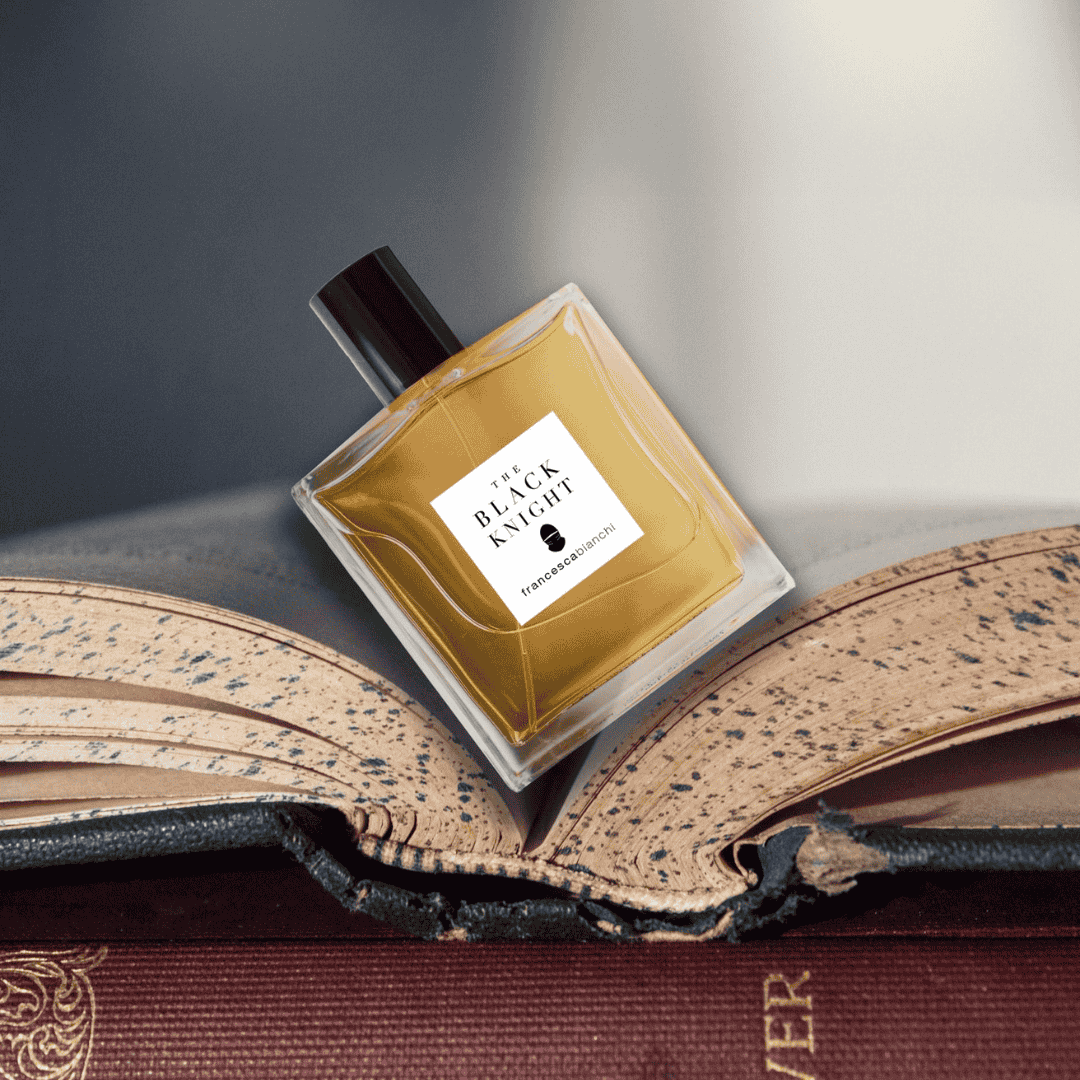 Flakon von Francesca Bianchi The Black Knight Extrait de Parfum auf aufgeschlagenem Buch, erlebe ihn bei scent amor