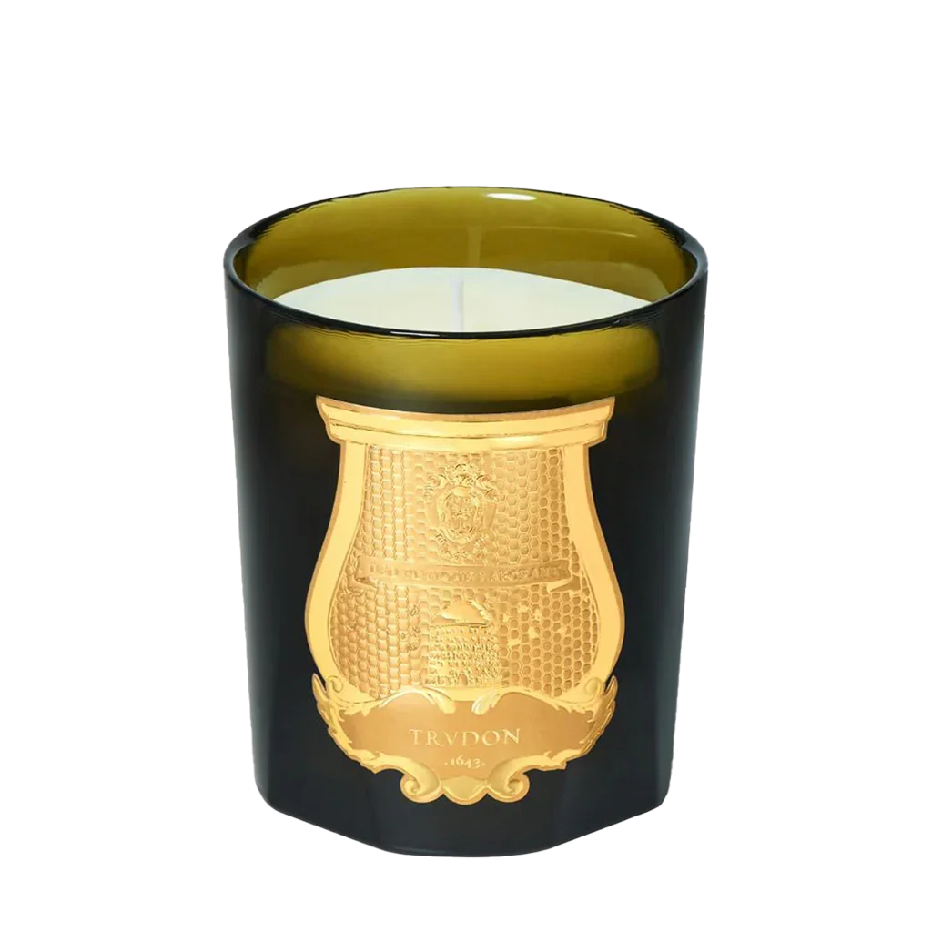 Duftkerze "GABRIEL" von Trudon mit einem goldenen Emblem auf schwarzem Glas, weiße Wachsschicht oben sichtbar.