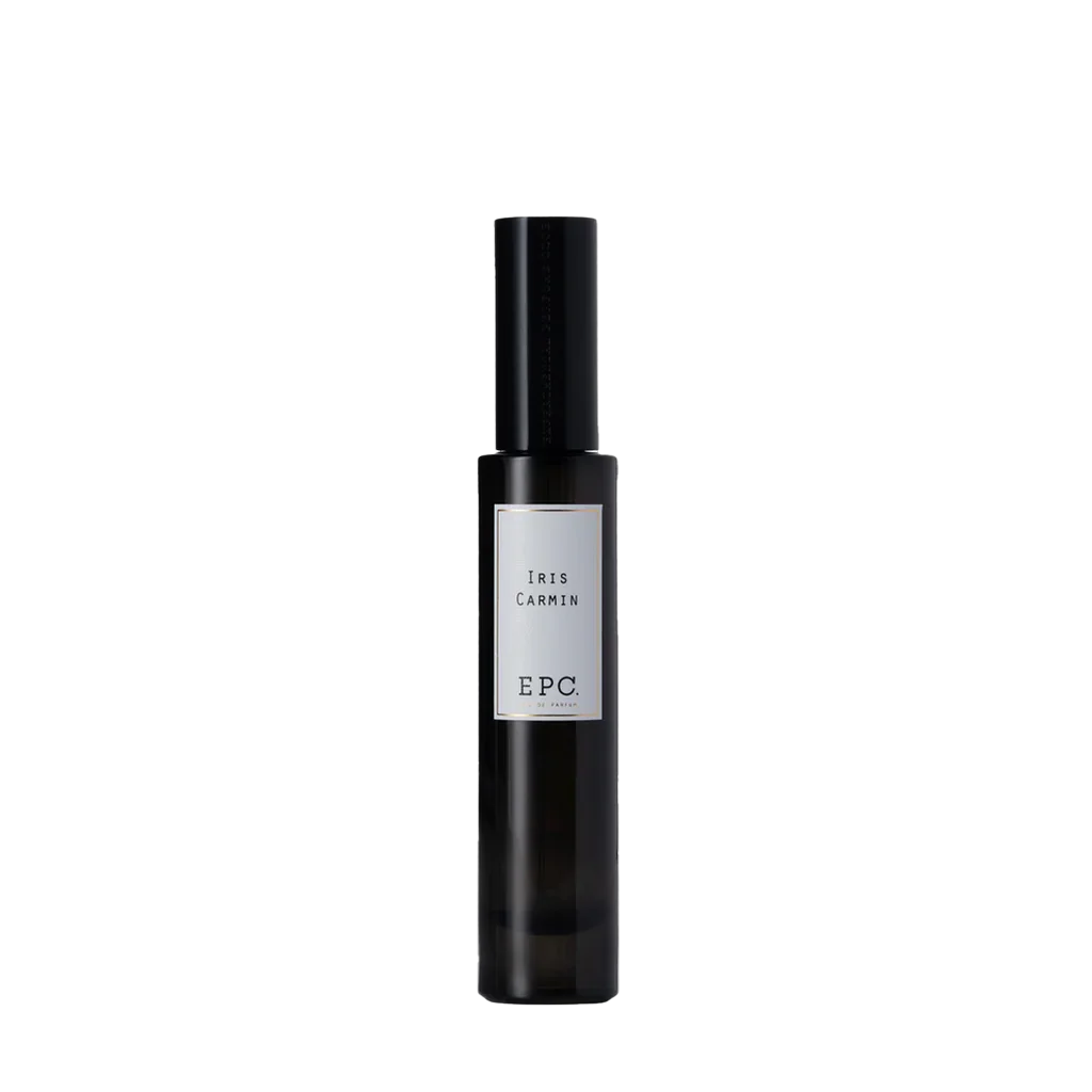 Dunkle, zylindrische Parfümflasche mit Etikett "Iris Carmin" von Experimental Perfume Club auf der Vorderseite.