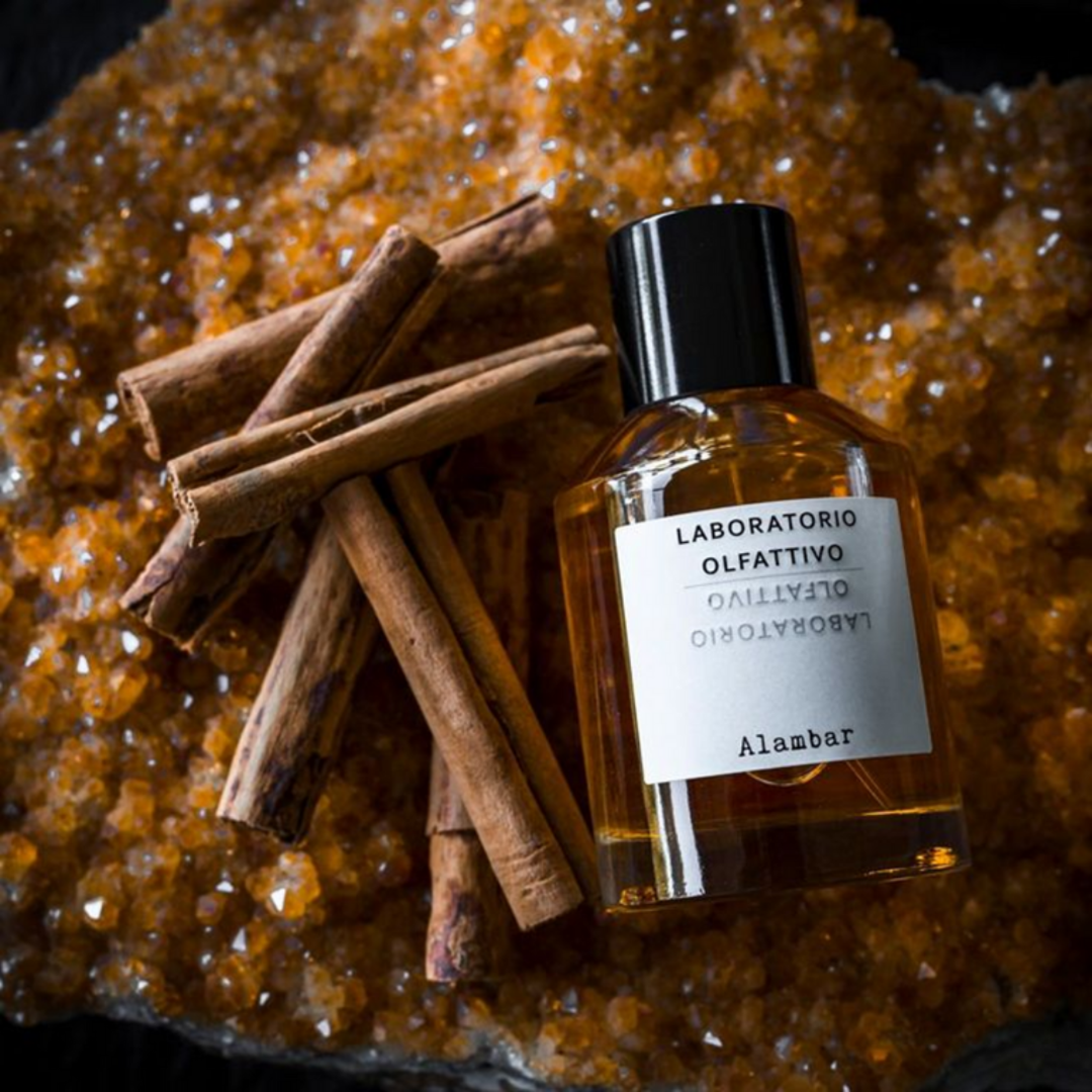 Duftbild zu dem Eau de Parfum Alambar von Laboratorio Olfattivo mit Zimtstangen und amberfarbenen Harzkristallen, warm, würzig und sinnlich inszeniert, erhältlich bei scent amor.