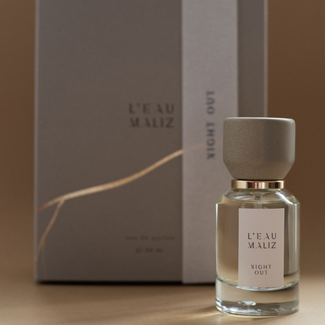L’Eau Maliz Night Out Eau de Parfum, Flakon vor der passenden Box in ruhiger Studioinszenierung, erhältlich bei scent amor.
