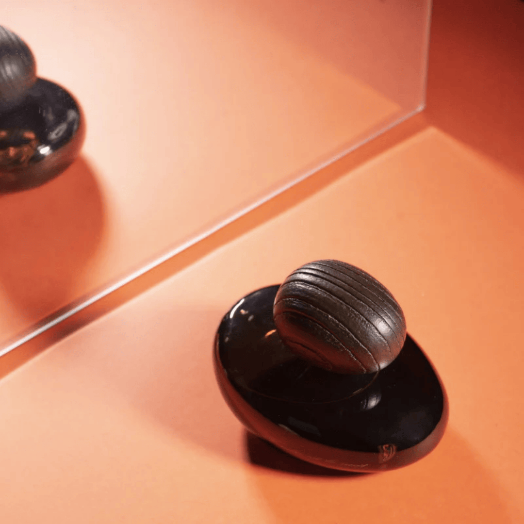 Majda Bekkali Tendre est la Nuit Obscur Extrait de Parfum, inszeniert mit Spiegelung auf warmem Hintergrund, elegant und modern, erhältlich bei scent amor.