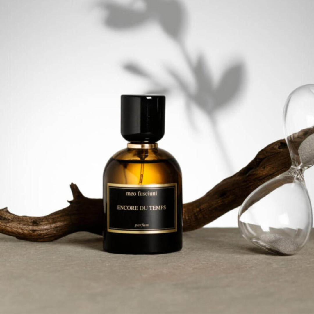 inszenierter Flakon von dem Eau de Parfum Encore Du Temps von Meo Fusciuni mit Holz und Sanduhr, kontemplativer holzig-harziger Duft über Zeit und Erinnerung, erhältlich bei scent amor.