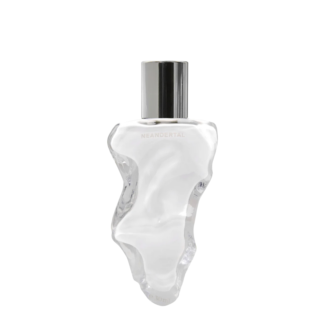 Neandertal is™ Eau de Parfum, skulpturaler transparenter Flakon mit milchiger Duftflüssigkeit, moderner avantgardistischer Nischenduft, erhältlich bei scent amor.