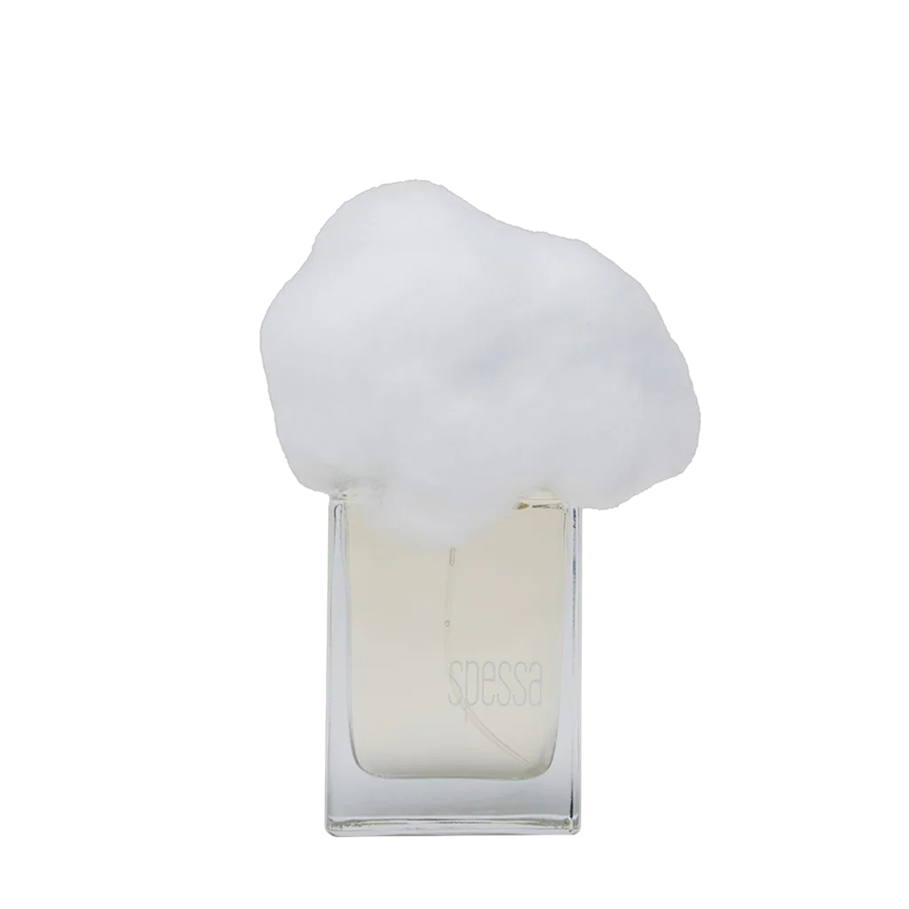 Klares Parfümflakon mit durchsichtigem Glas, darauf "spessa" graviert. Weiße, wolkenähnliche Kappe. Produkt: NEBBIA SPESSA, Hersteller: Filippo Sorcinelli.