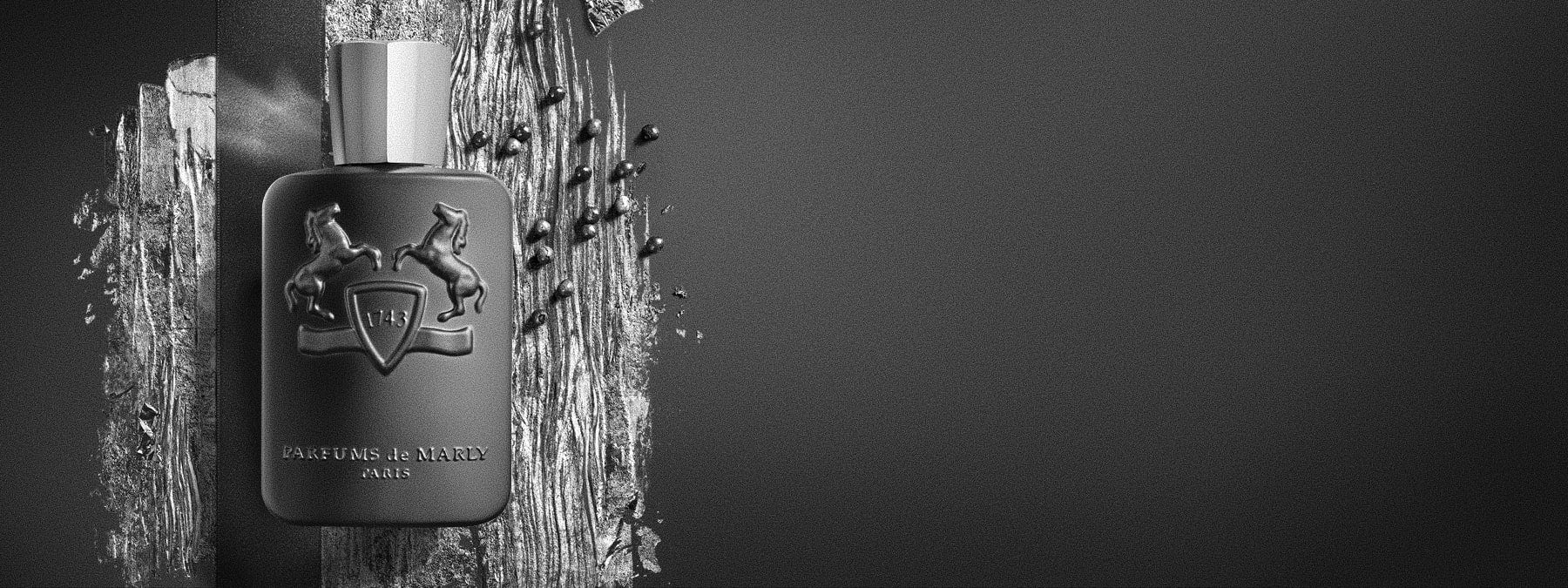 Nischenduft Marke Parfums de Marly grauer Flakon auf grauem Hintergrund mit Beeren