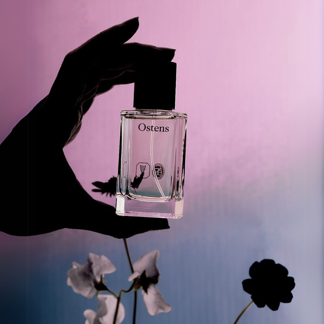 Flakon aus der Kollektion von Nischendüften der Marke Ostens mit einer Hand als Schatten und Blüten