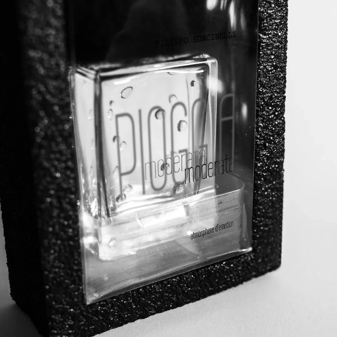 Klares Parfümflakon "PIOGGIA MODERATA" von Filippo Sorcinelli, umgeben von einer schwarzen, texturierten Verpackung.