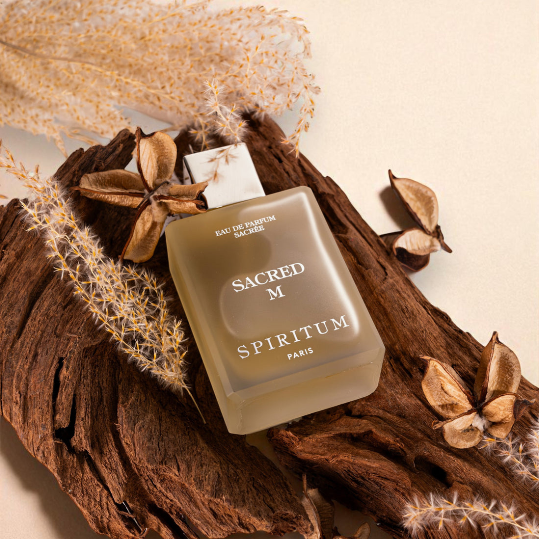 scent amor Spiritum Paris Sacred M Eau de Parfum, Flakon liegend auf Holz mit trockenen Pflanzen und Naturdetails, warmes aromatisches Ambiente, erhältlich bei scent amor