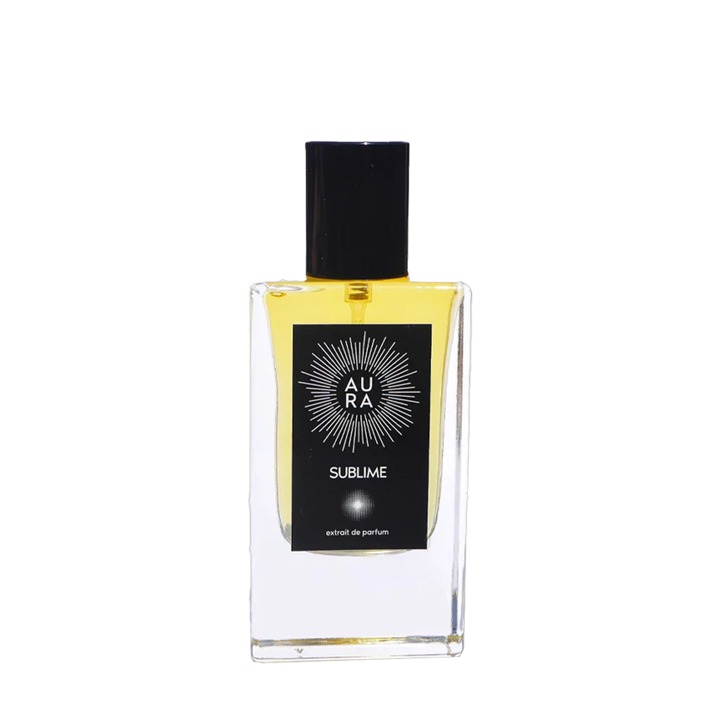 Das Produkt "Sublime" von Aura Perfume ist ein klarer rechteckiger Flakon mit schwarzem Deckel. Auf der Vorderseite befindet sich ein schwarzes Etikett mit weißem Grafikdesign und der Aufschrift "AURA SUBLIME extrait de parfum".