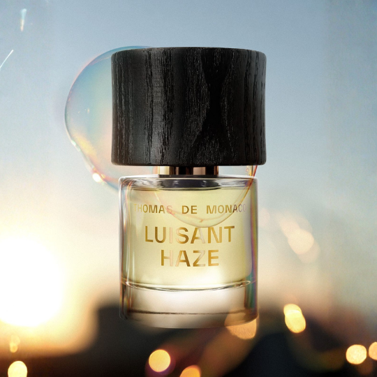 Thomas de Monaco Luisant Haze Extrait de Parfum, Flakon im warmen Sonnenlicht mit schimmernden Reflexionen und sanften Lichtspielen, strahlender Duftcharakter, erhältlich bei scent amor.