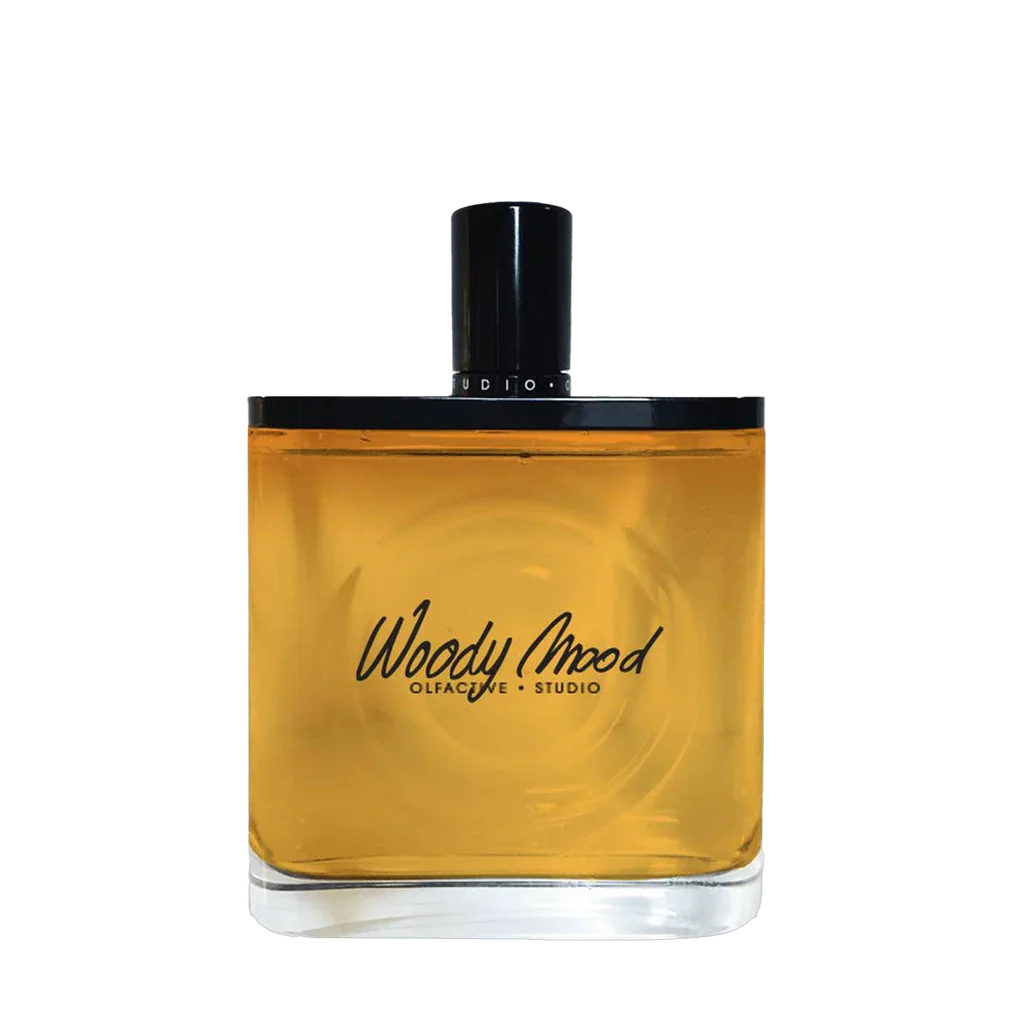 Flakon des Parfums "Woody Mood" von Olfactive Studio, transparent mit bernsteinfarbener Flüssigkeit und schwarzem Deckel.