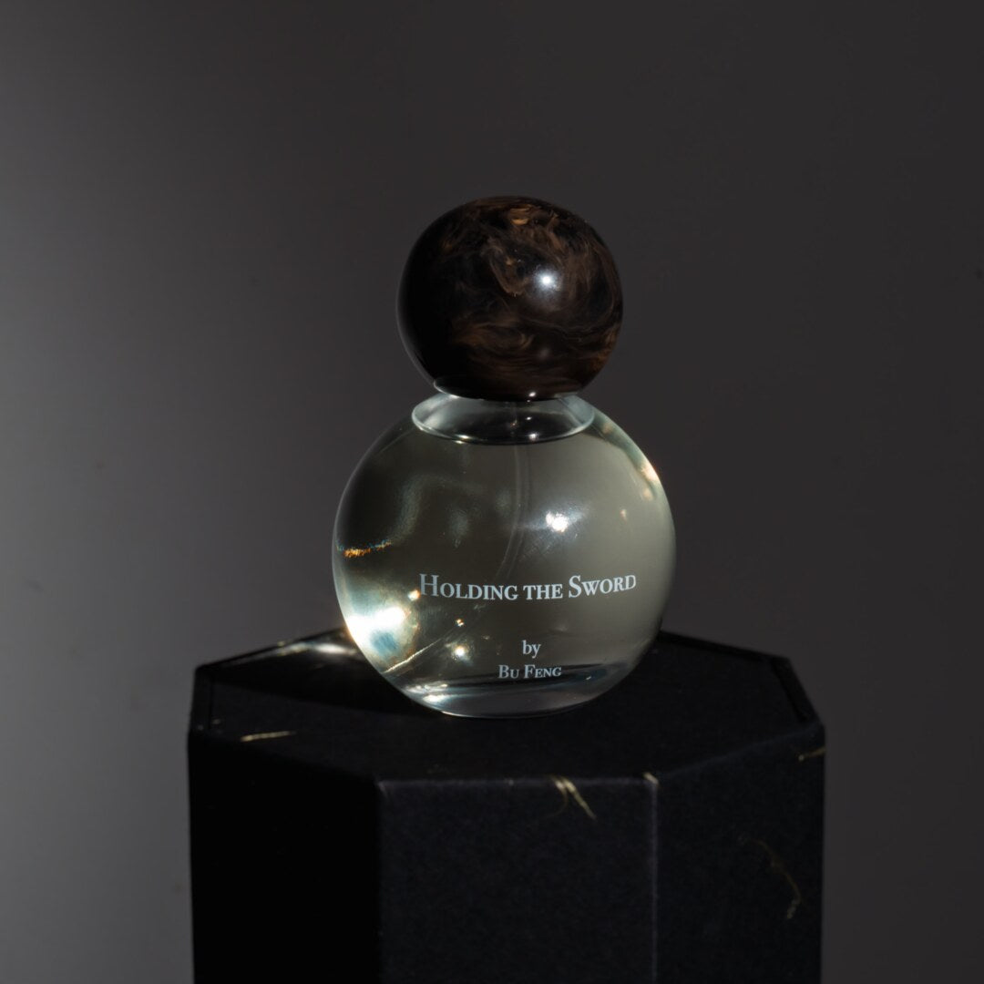 Bu Feng Eau de Parfum Holding the Sword Nischenduft Flakon dunkelgrau präsentiert auf schwarzem Sockel bei scent amor Fachmann für feine Nischenparfums