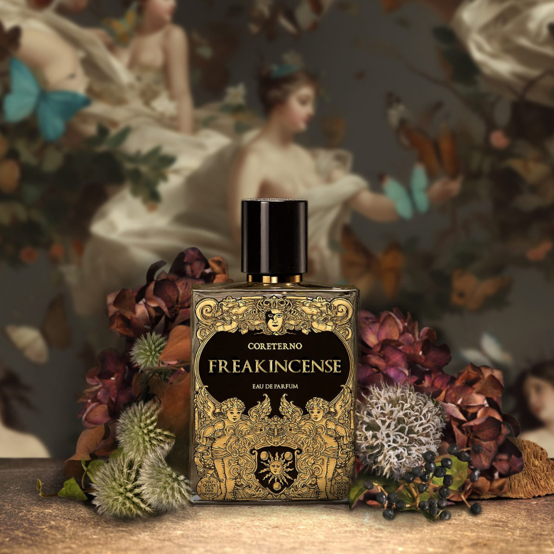Coreterno Freakincense Eau de Parfum - eleganter Nischenduft mit intensiven Harznoten im goldenen Designflakon vor kunstvollem Gemälde und Blumen, erhältlich bei scent amor