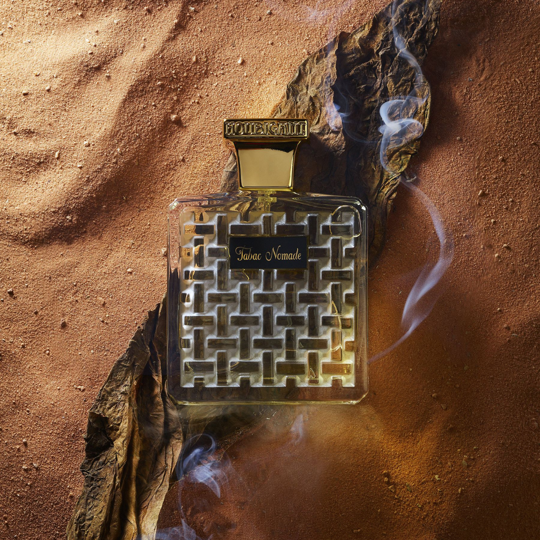 Houbigant TABAC NOMADE Eau de Parfum Mood Flakon auf rotem Sand mit Rauch scent amor