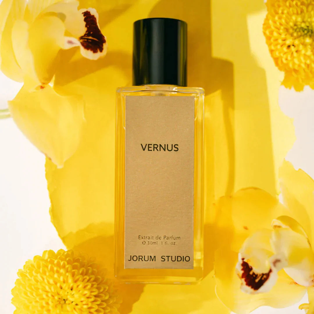 Jorum Studio Vernus Extrait de Parfum – der Flakon steht zwischen gelben Blüten, ein Bild voller Leichtigkeit und floraler Harmonie – erlebe den Nischenduft bei scent amor