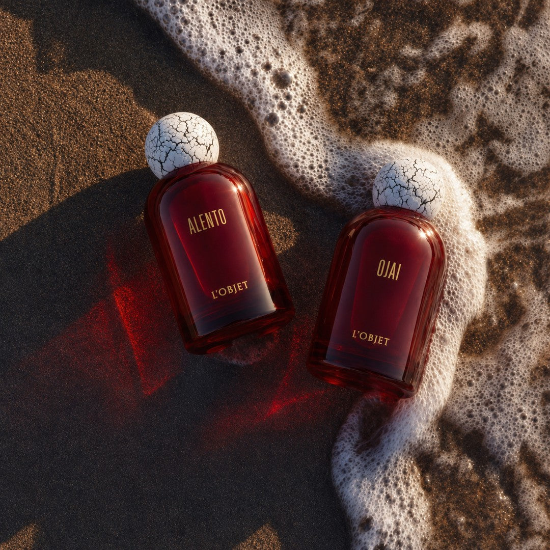 L’OBJET OJAI Eau de Parfum mit ALENTO Eau de Parfum am Strand auf Sand in der Gischt