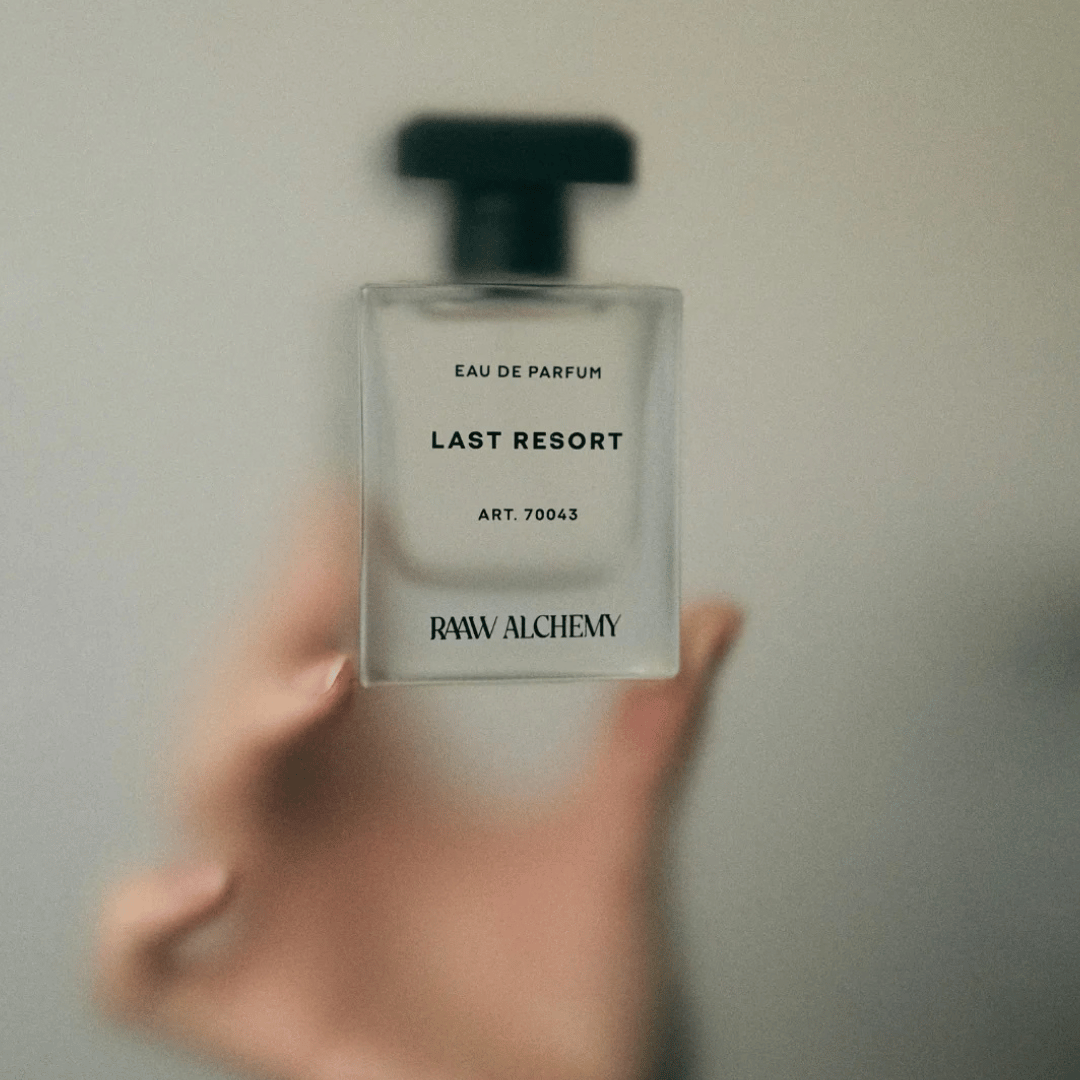 Last Resort Raaw Alchemy in einer Hand gehalten hinter matter Glasscheibe präsentiert bei scent amor Fachmann für Nischenduft