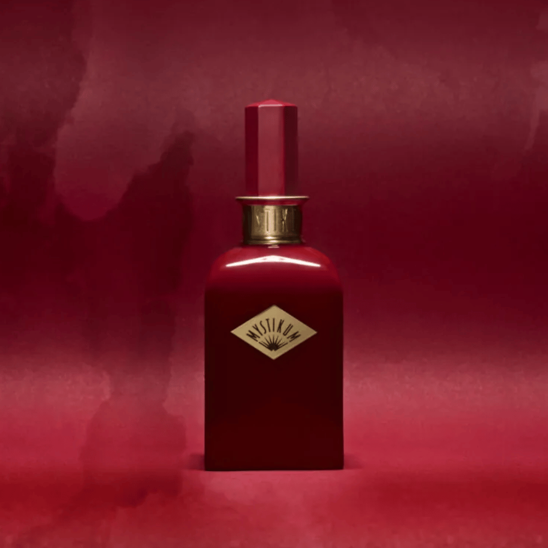 Mystikum Forbidden Rouge Flakon beim Fachmann für Nischenparfums scent amor kuratiert von Georg R. Wuchsa vor rot marmoriertem Hintergrund