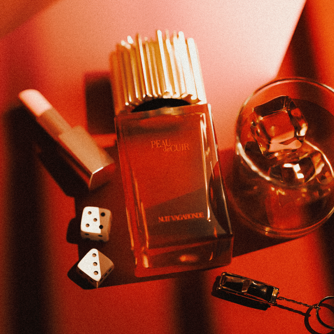 Peau de Cuir Nuit Vagabonde Nischenduft Mood Flakon liegend mit Drink Würfel und Lippenstift bei scent amor kuratiert von Georg R. Wuchsa