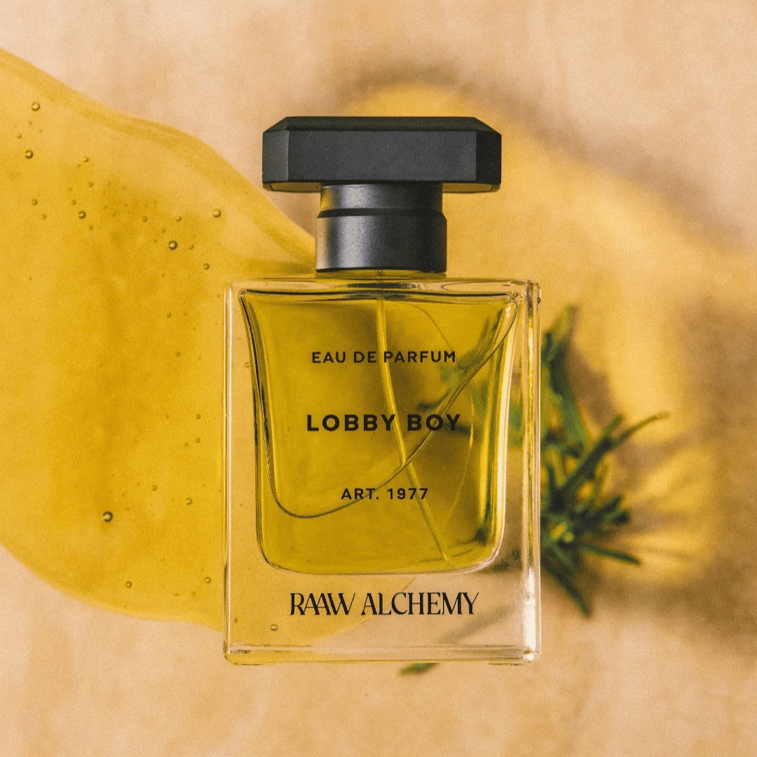 RAAW ALCHEMY – LOBBY BOY Eau de Parfum vor gelber Flüssigkeit und Rosmarin bei scent amor Deinem Fachmann für feine Nischendüfte