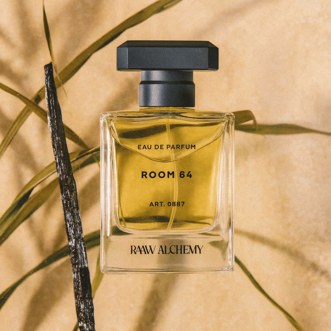 RAAW ALCHEMY ROOM 64 Eau de Parfum Flakon vor Vanille Schote und grünem Kraut präsentiert bei scent amor Deinem Fachmann für feine Nischenparfums