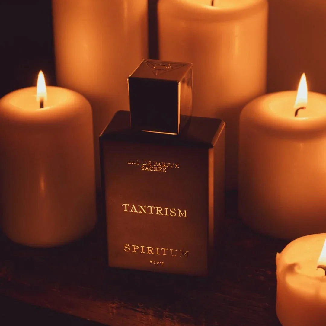 Spiritum Paris TANTRISM Eau de Parfum – der Flakon steht zwischen angezündeten Kerzen, eine Szene voller Spiritualität und warmer Leuchtkraft, die die mystische Seite des Dufts hervorhebt – erlebe ihn bei scent amor