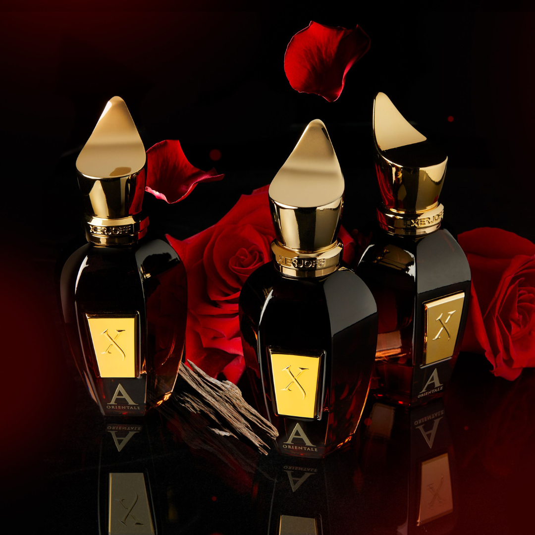 Drei Flakons von Xerjoff Alexandria Orientale Eau de Parfum umgeben von roten Rosen – luxuriöser Oud-Duft aus der Oud Stars-Kollektion, jetzt bei scent amor erleben